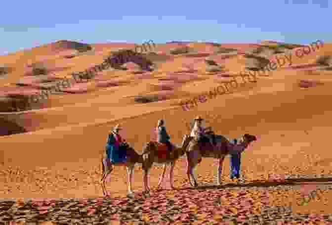 A Group Of Camels Walk Across The Sand Dunes In The Sahara Desert. To The Ends Of The Earth: The Selected Travels Of Paul Theroux